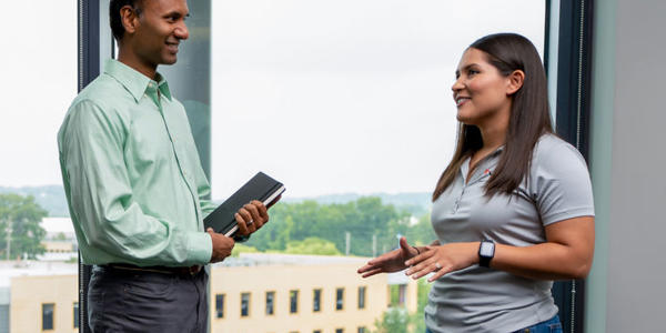 a man and woman standing in front of a window