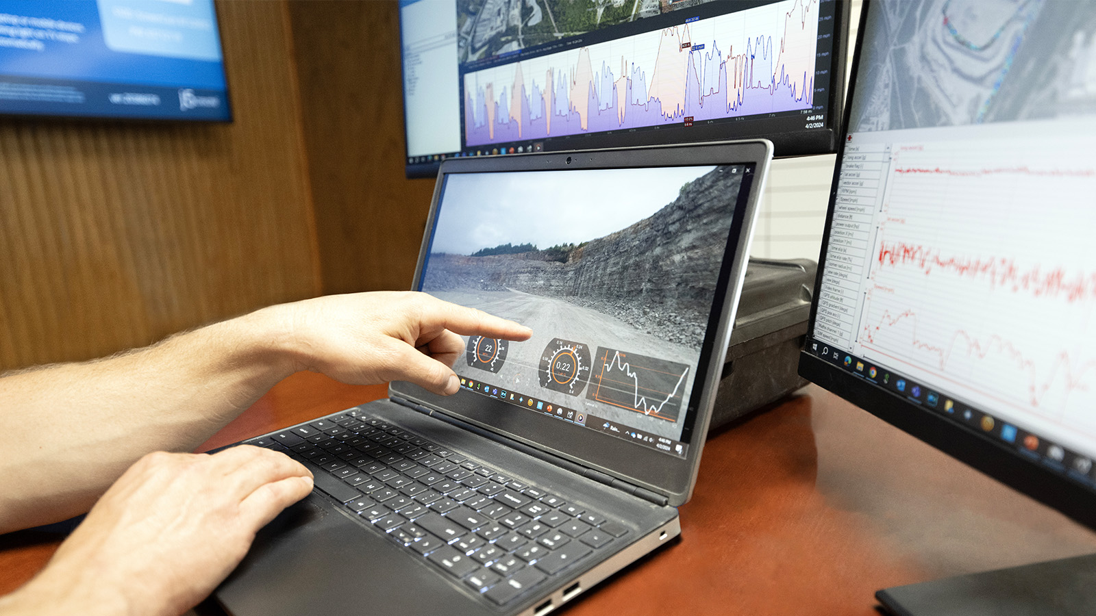 a person pointing at a laptop