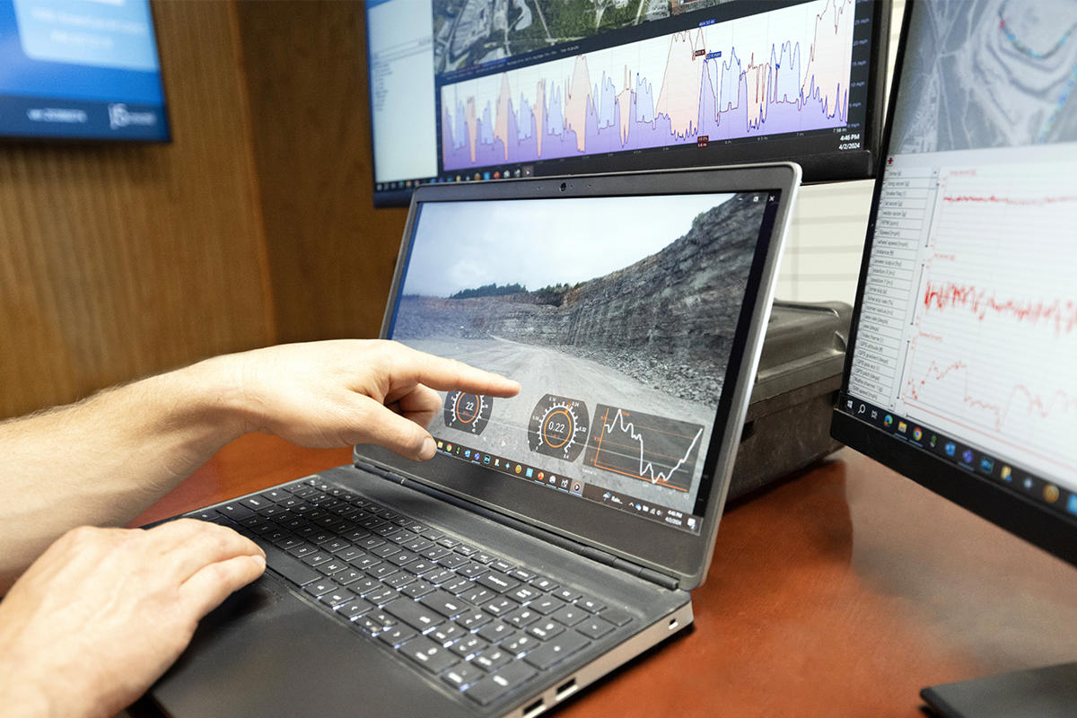 a person pointing at a laptop