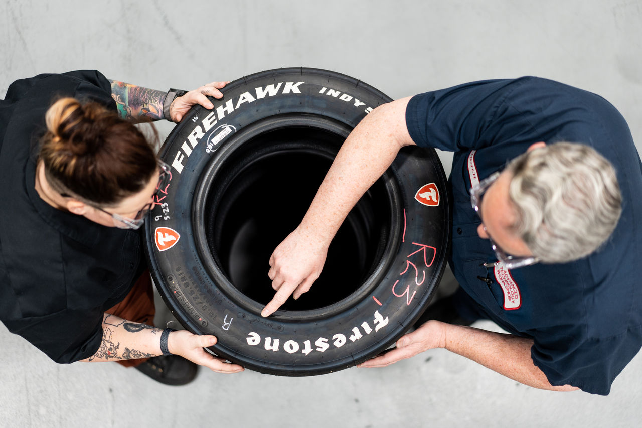 a man and woman holding a tire