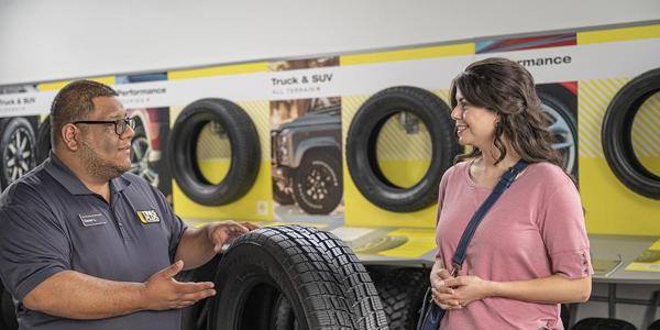 a man and woman looking at tires