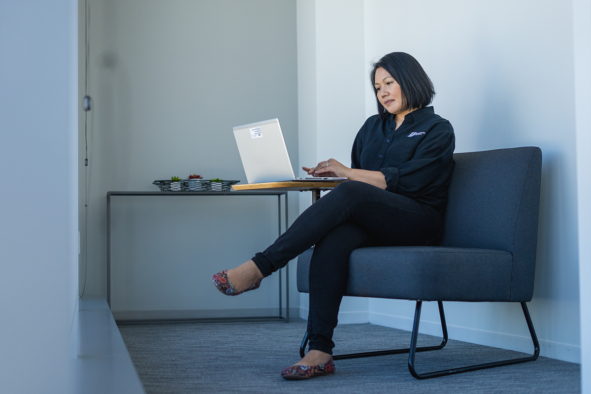 a woman sitting on a couch using a laptop