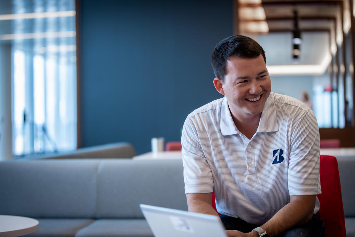 a man smiling while sitting on a couch