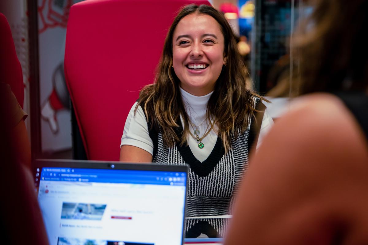 a woman sitting in a red chair smiling