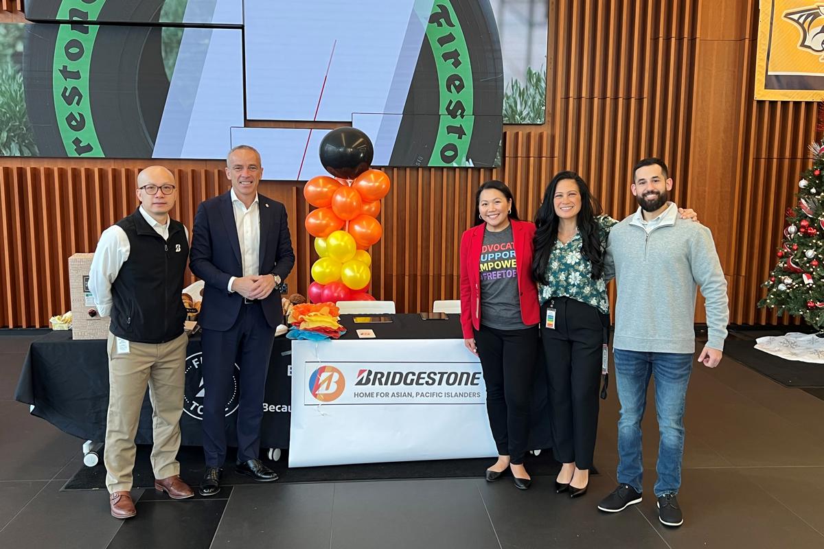 a group of people standing in front of a table with balloons