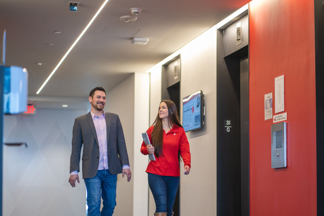a man and woman walking in a hallway