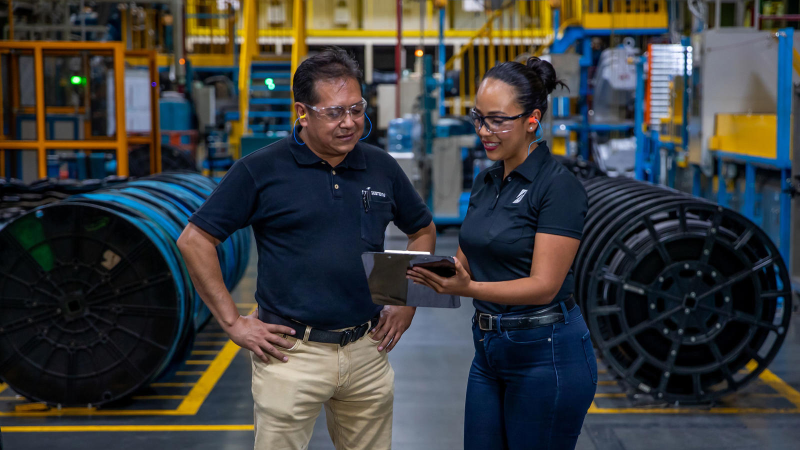 a man and woman standing in a factory